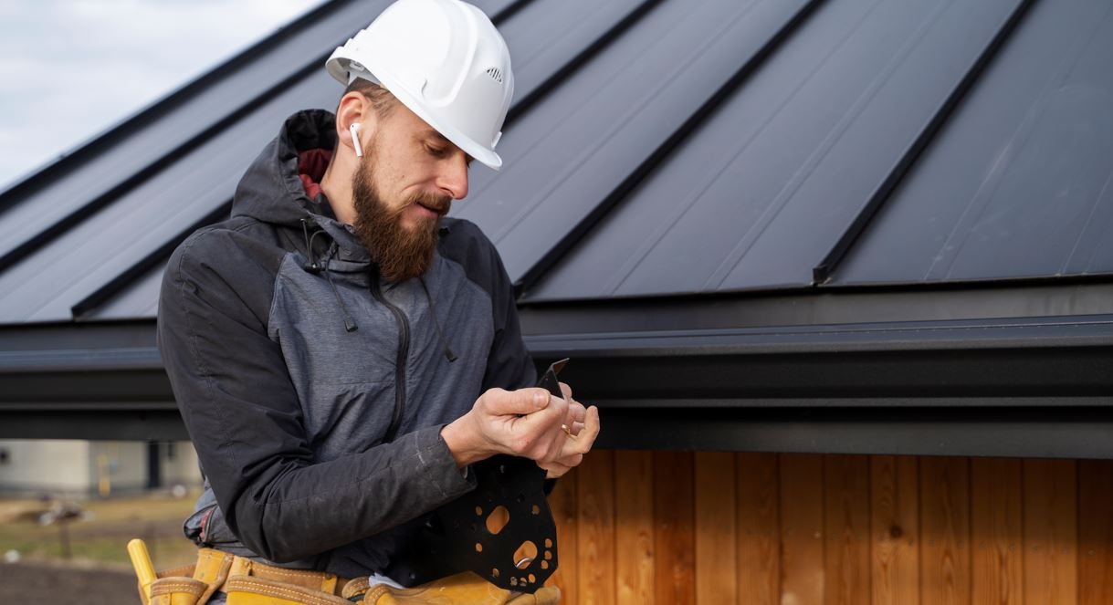 Contractor installing seamless aluminum gutters on a home